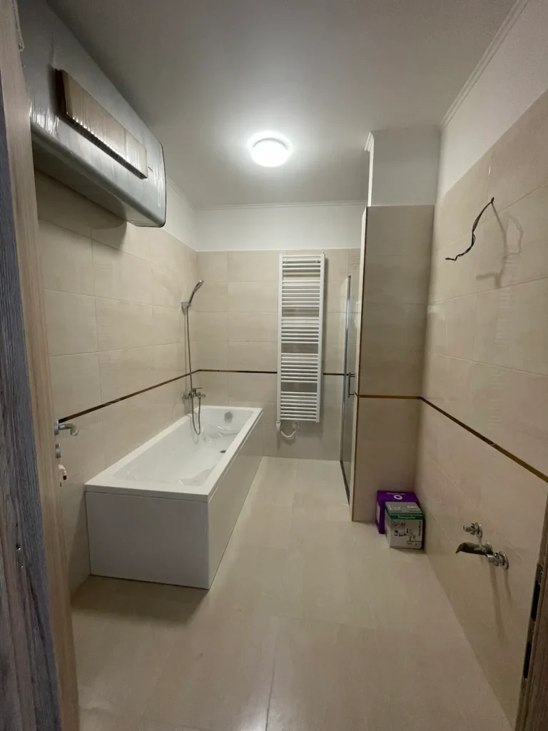 Modern berendezett fürdőszoba fürdőkáddal, törölközőszárítóval