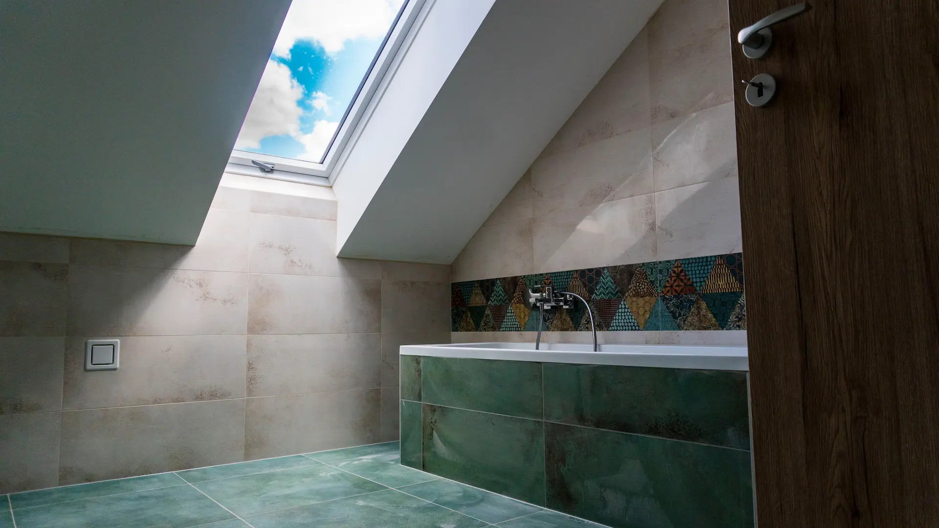Zöld csempés fürdőszoba, fényes tetőablakkal