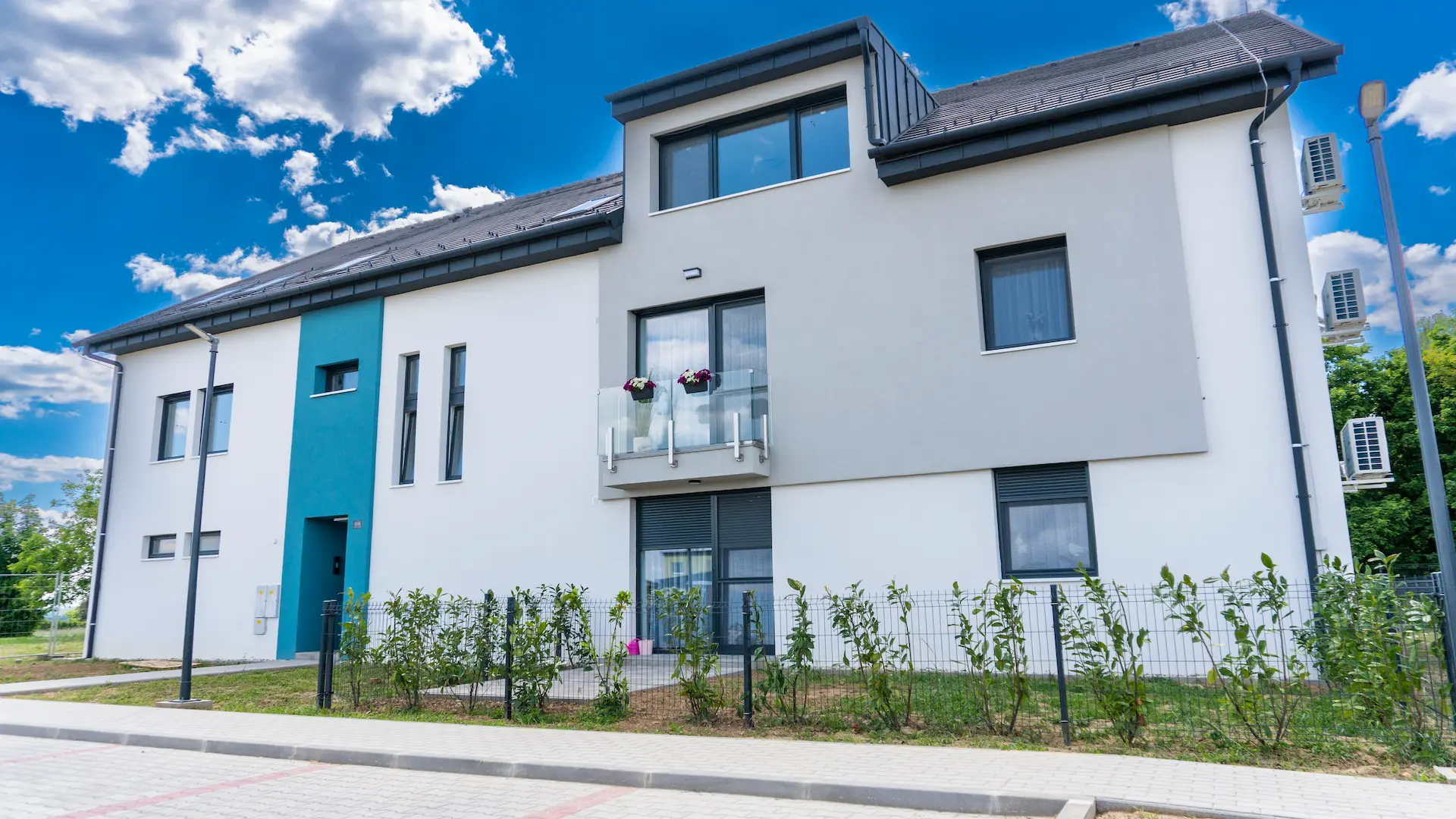 Társasház parkolókkal előtte